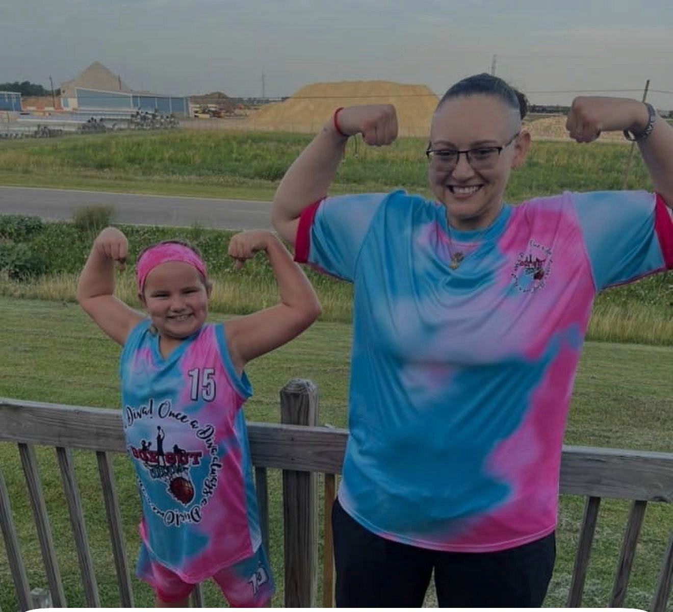 Mom and daughter flexing in custom pink and blue Capra jerseys