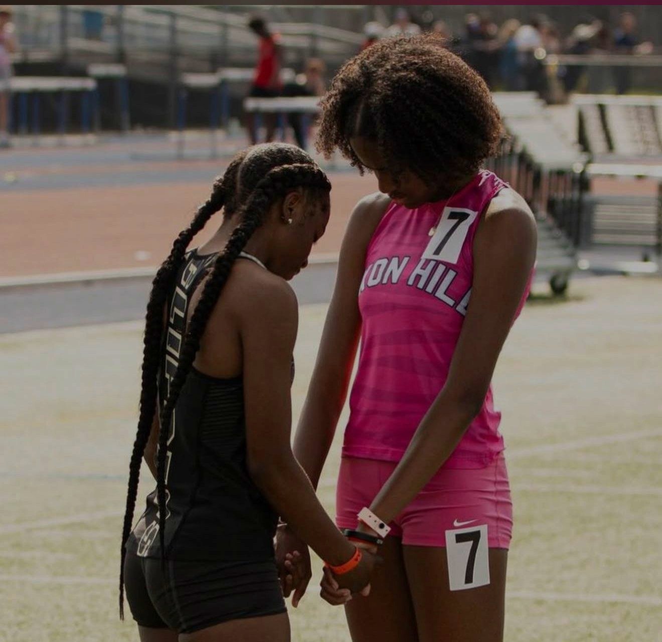 Track athletes in custom Capra singlets before a race
