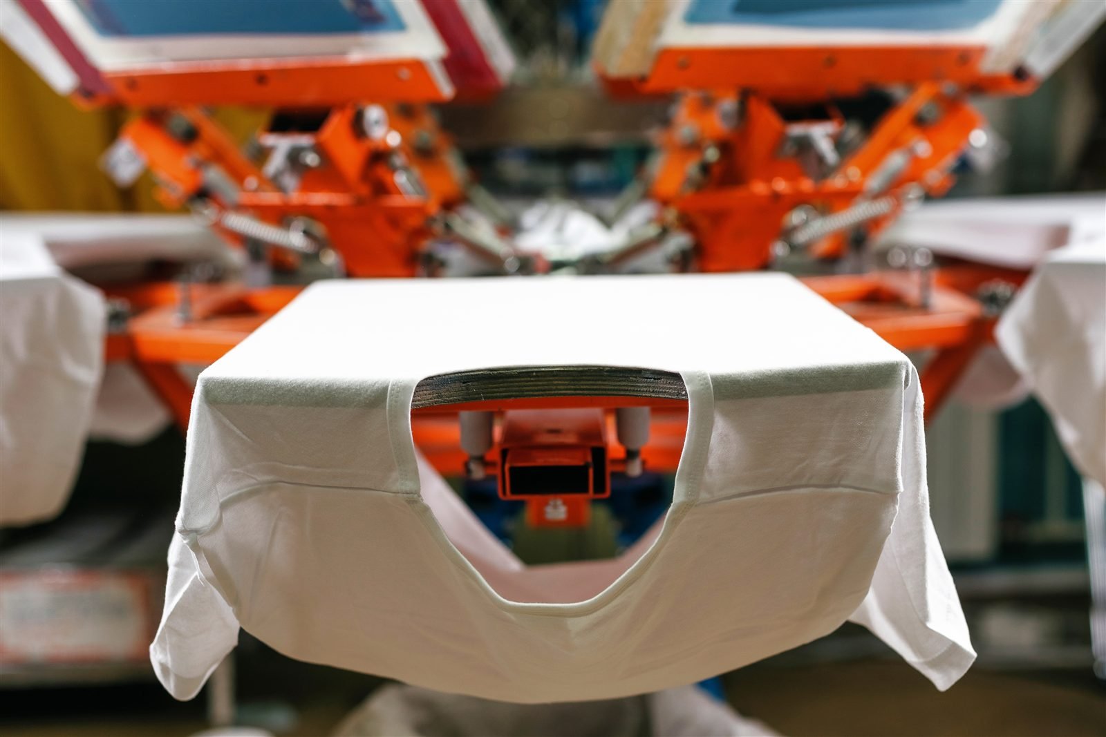 Pre-made blank shirt loaded on a screen printing press waiting to be decorated