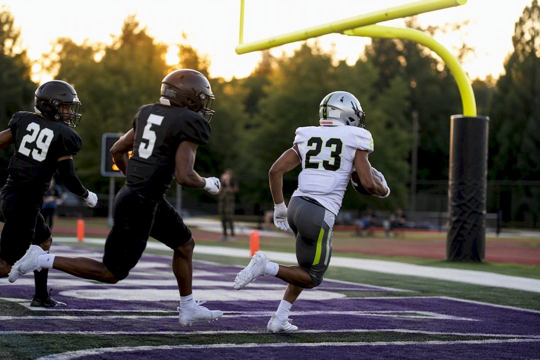 Linebacker running on football field showing jersey numbers