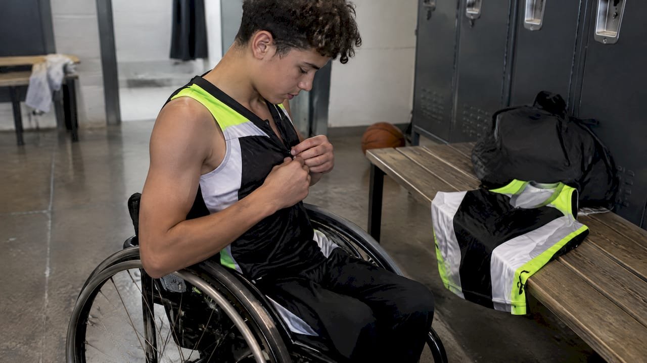 Wheelchair athlete fastening adaptive team jersey